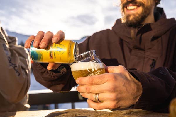 man pouring athletic non-alcoholic beer into glass